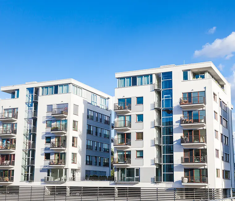 Moderne Mehrfamilienhäuser mit Balkonen vor blauem Himmel