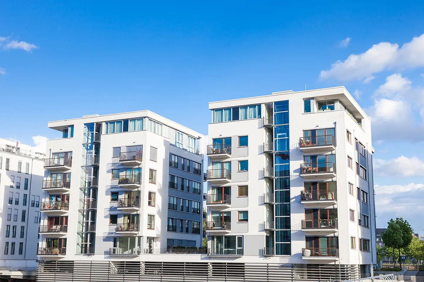 Moderne Mehrfamilienhäuser mit Balkonen vor blauem Himmel