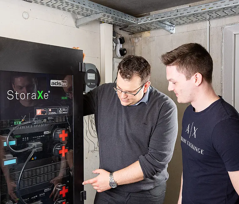 Zwei Mitarbeiter bei der Inbetriebnahme eines Batteriespeichers